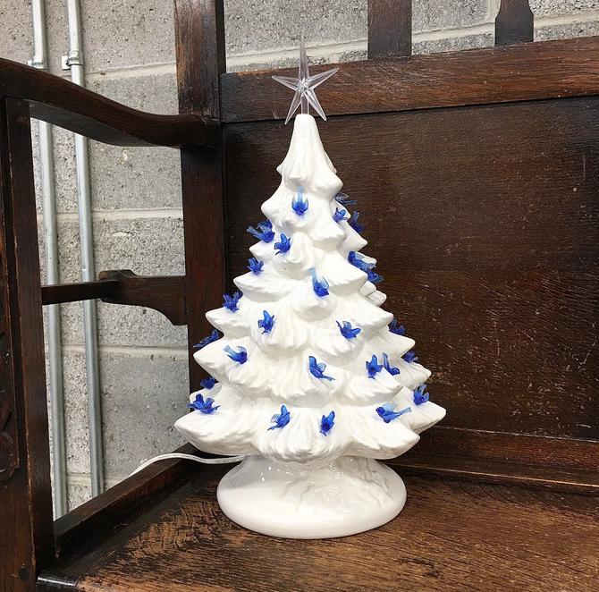 white ceramic christmas tree with blue bird lights