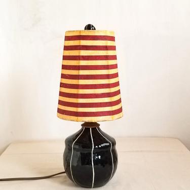 Black ceramic table lamp with striped shade. Bedside lighting. 