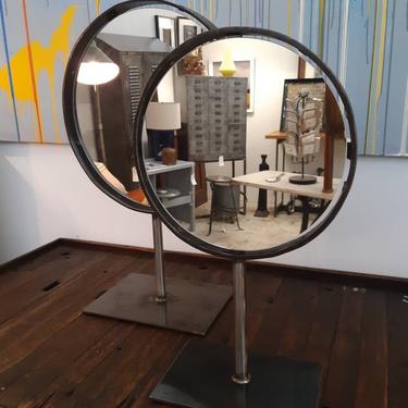 Vintage industrial salvaged cast iron wheel frame mirrors on a stand. 