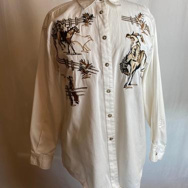 Western shirt~ 100% cotton~ embroidered cowboy novelty print~ horses cowboys~ pearly shell snaps down the front~ 1990s Unisex size Medium 
