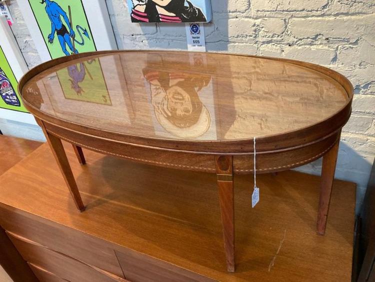 Oval glass topped coffee table with lovely marquetry inlay.  38.25” x 20” x 17.5”