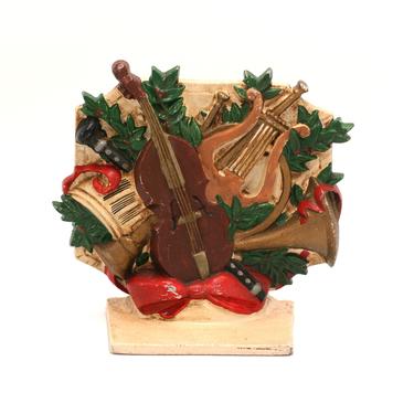 vintage cast iron door stop with musical instruments and christmas poinsettias 