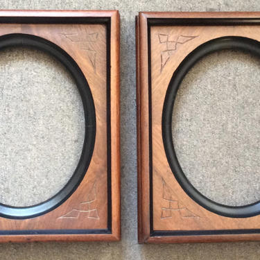 Pair Victorian walnut frames, oval openings, incise carving with ebonized highlights 