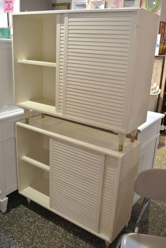 Pair of white, louvered door, MCM cabinets on brass-tipped legs