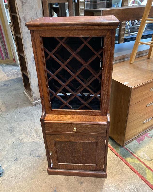 Stained oak wine cabinet. Locking bottom cabinet, holds 18 bottles. 22” x 18” x 52.5”