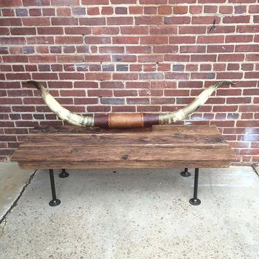 Raw wood coffee table with pipe fitting legs.