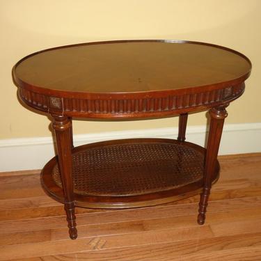 Beautiful oval side table with a rattan bottom.  Makes a perfect surface for drinks in a bar area, next to a reading chair or a bed.