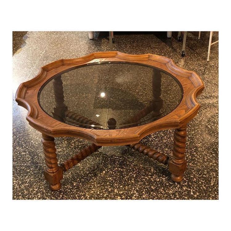 Round Beveled smoked glass coffee table surrounded by barley twist oak. 44” round x 17” Tall
