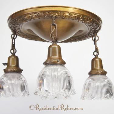 4-light brass flush-mount chandelier with Holophane glass shades, circa 1910s