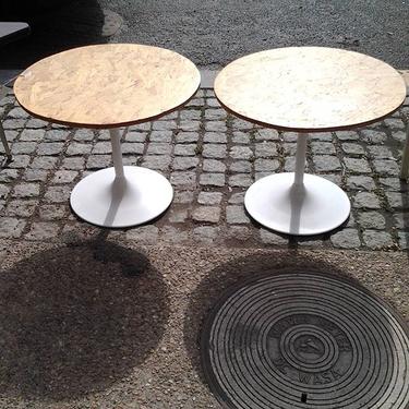 A pair of Saarinen style tulip tables with rounded cork tops.