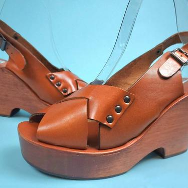 Deadstock 70s platform sandals. Cognac criss-cross leather. Buckle straps. Hippie wedges. Size 7. 