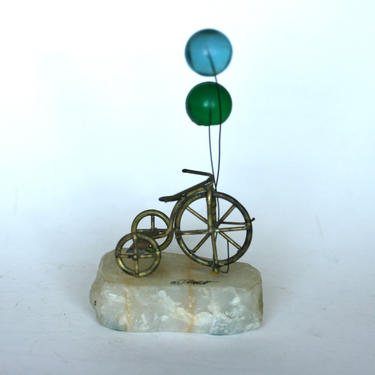 vintage Demott tricycle sculpture with balloons on quartz 
