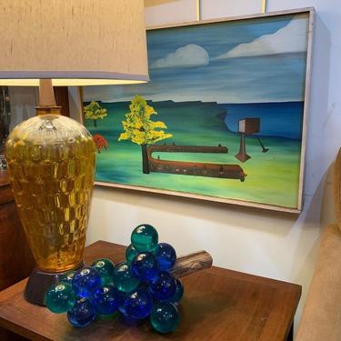 Brightly colored oil on board with lucite grapes and amber glass lamp.