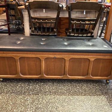 Long low Lane cedar chest, padded top (small tear to a corner) on wheels. 52.5” x 17.5” x 17”