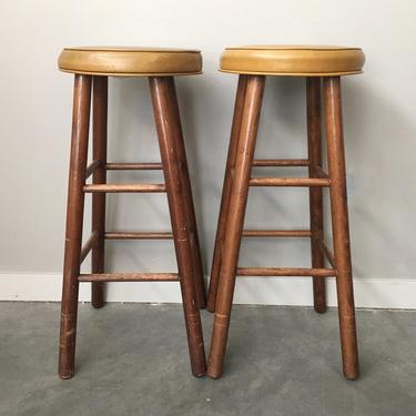 pair of vintage barstools with mustard seats.