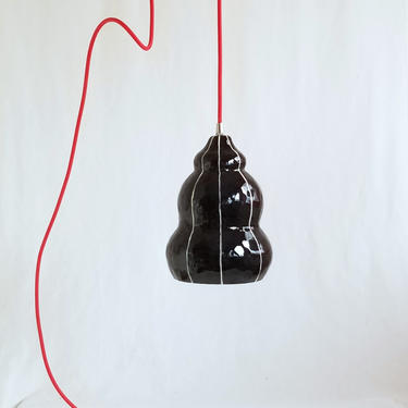 Handmade black ceramic pendant light. Red plug in cord 