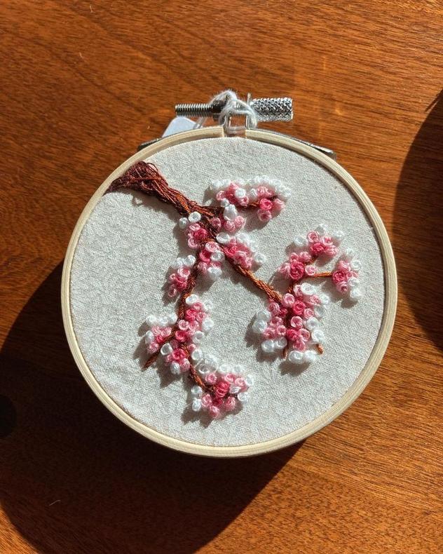 Little embroidered cherry blossom embroidery on patterned fabric. 5.5” hoop 