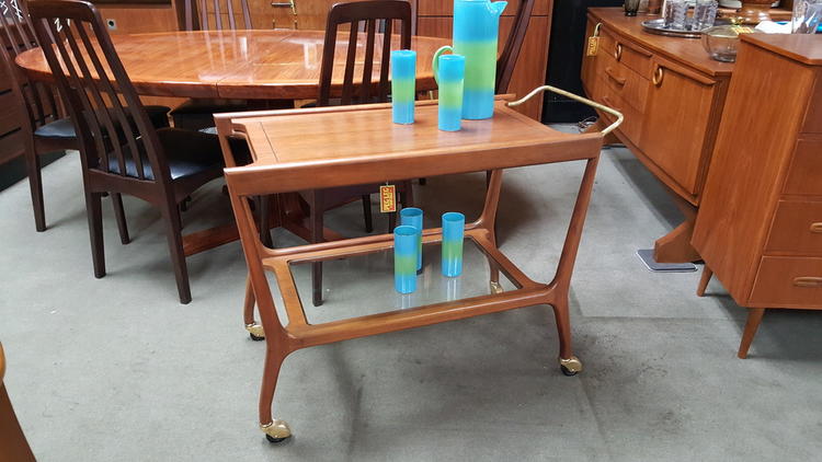 Mid-Century walnut bar cart with brass details, glass shelf, and retracting white laminate surface