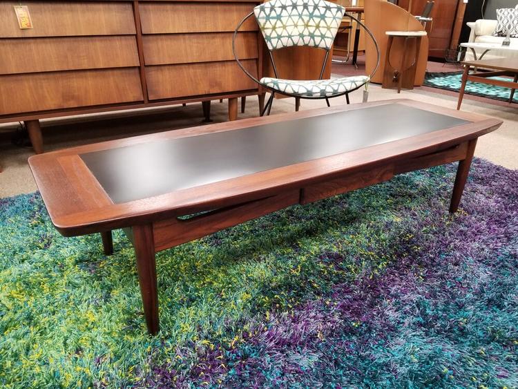 Mid-Century walnut and black surfboard coffee table with lower drawer by American of Martinsville