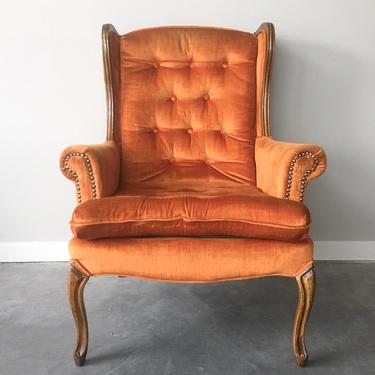vintage plush orange wingback chair.