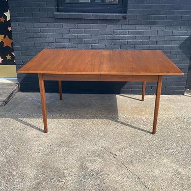 Mid Century dining table, accompanied by three leaves. 64” L (124” L with leaves) x 42” W x 29” T. 