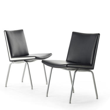 Set of two black vinyl and steel Kastrup chairs by Hans Wegner made by A.P. Stolen 