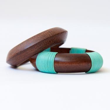 two wood bangles with turquoise thread 